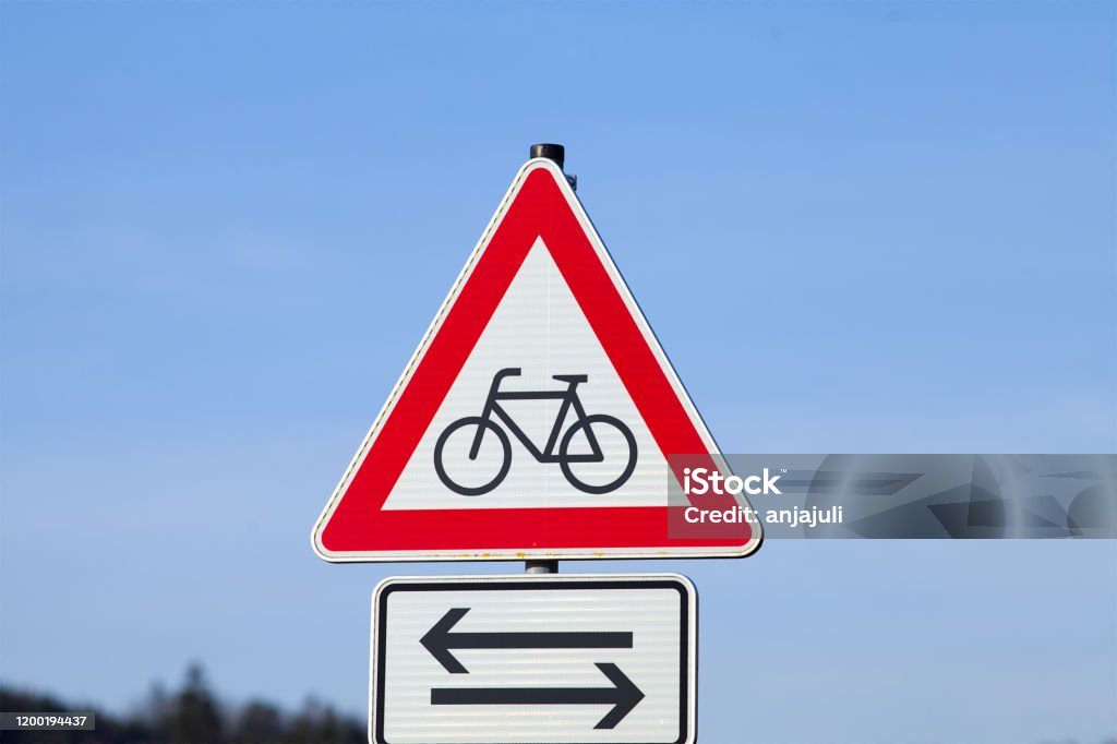 Shield Attention Cyclist. Warning of cyclists crossing the road Sign Attention cyclists. Warning of crossing cyclists on the road Germany Stock Photo