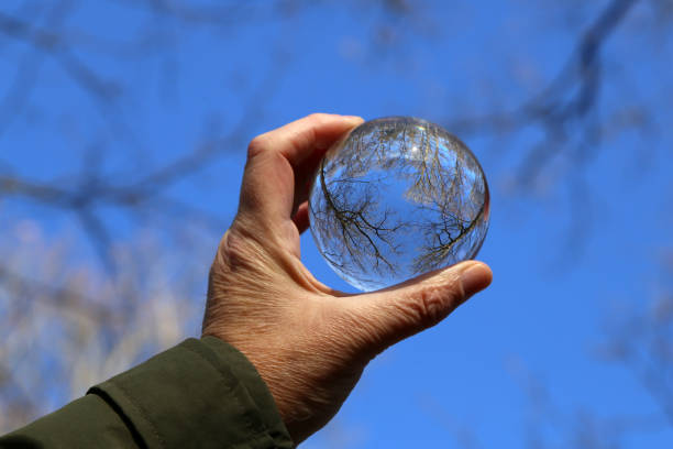 istock Trees and blue sky through a transparent glass ball 1200196064