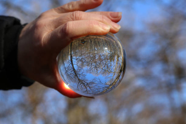 istock Trees and blue sky through a transparent glass ball 1200196093