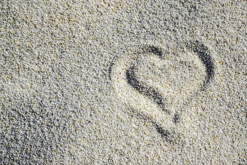 Small painted heart on white sand