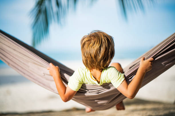 istock Rear view small boy swinging at the beach 1200200859