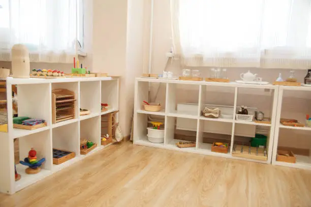 Shelving in a Montessori class with wood and glass material.