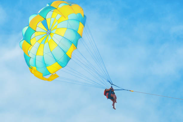 istock People on a yellow-blue parachute against a cloudy sky 1200205701