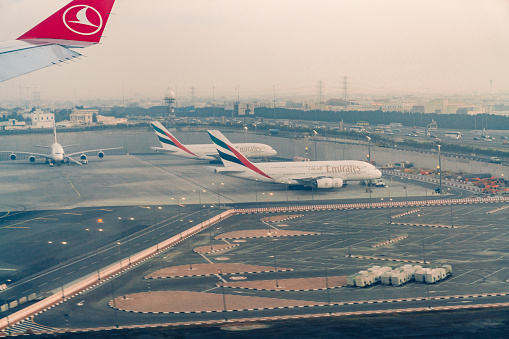 Aerial view of Dubai airport and Emirates planes on the terminal.