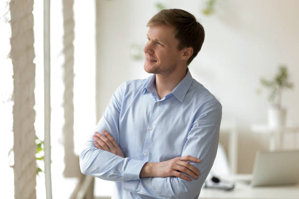istock Dreamy businessman looking outside window at office. 1200214118
