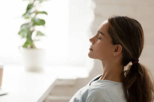 Photo of Side view young mixed race woman relaxing with closed eyes.