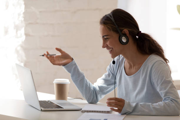 istock Smiling millennial lady freelancer wearing headset, communicating with client. 1200214144