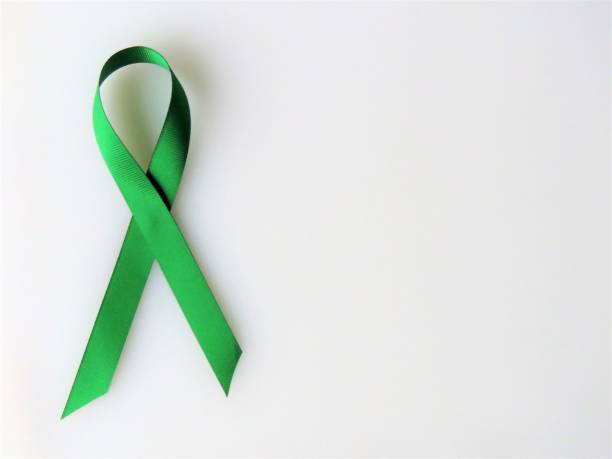Green ribbon, White background--Awareness month: mental heath Green ribbon, Awareness month: mental health. White background. Copy space. Christine Kohler stock pictures, royalty-free photos & images
