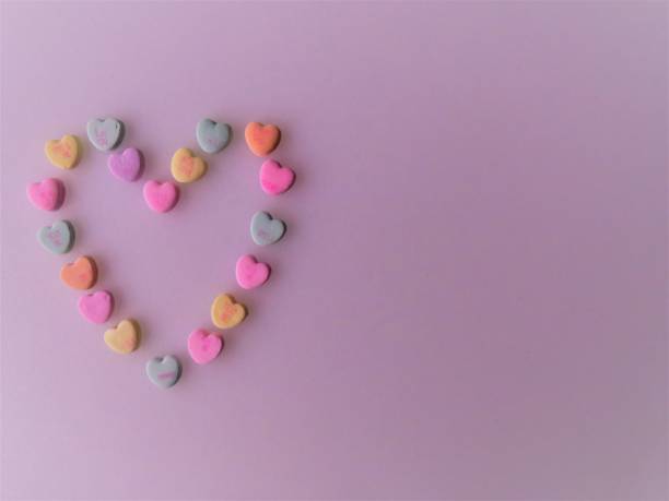 Heart-shaped candies form a Valentine, rose background
