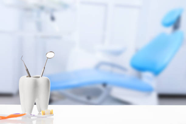 구강 치과 위생. 치과 의자와 램프가있는 흐린 치과 의사 사무실 배경에 대한 칫솔 근처의 탐색기 프로브 기구가있는 건강한 흰색 치아와 치과 용 거울. - dentist office work tool hygiene mirror 뉴스 사진 이미지