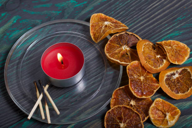 istock Candle on brushed boards. Around dried oranges. Burnt matches. 1200254805