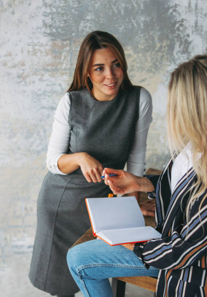 istock Young successful women colleagues discuss joint project, coaching or mentoring in modern loft office 1200259014