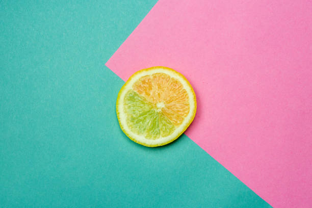 istock Lemon slice close up with a pink and blue background - Flat lay fruit 1200260476