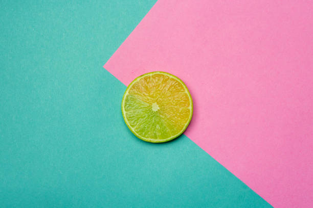 istock Lime slice close up with a pink and blue background. Fresh fruit in summer, flat lay 1200261085