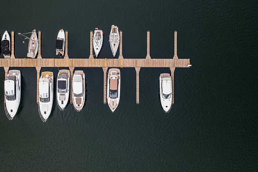 Yachts port with wooden footbridge on top down view.