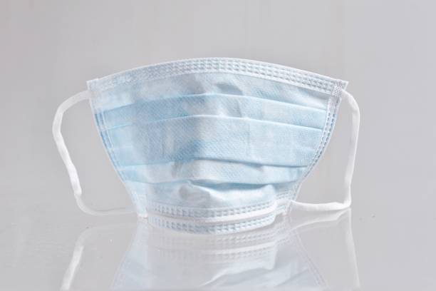 istock Close-Up Of Surgical Mask Against White Background 1200276534