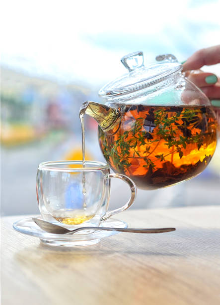 istock From a glass kettle pour tea into a glass cup on a light background 1200277038