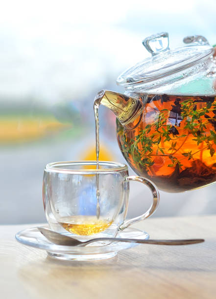istock From a glass kettle pour tea into a glass cup on a light background 1200277122