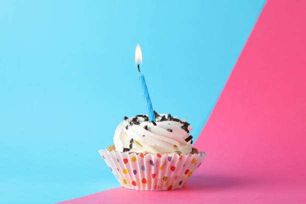 istock Cupcake with candle on two tone background, space for text 1200277456