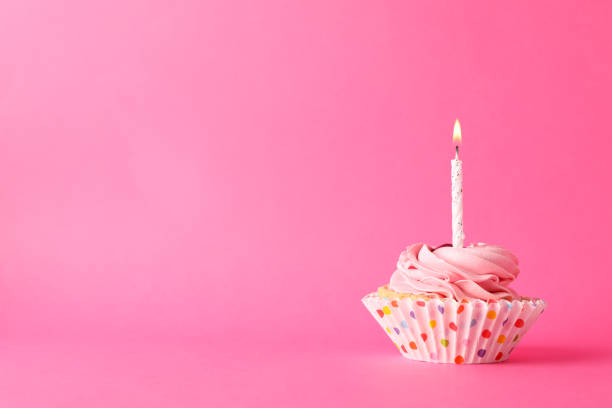 istock Cupcake with candle on pink background, space for text 1200278171