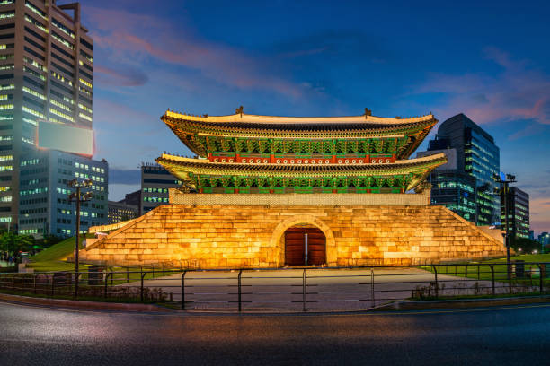 Illuminated Namdaemun Gate at Night - Twilight in Downtown Seoul. Motion blurred cars driving by the famous Namdaemun Gate. Seoul City,  South Korea, Asia.