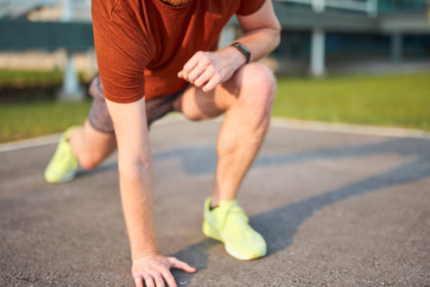 istock Young man exercising / stretching in urban park. 1200280599