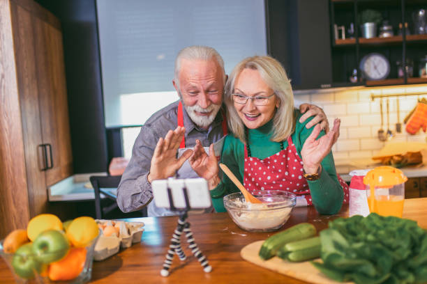 老年夫婦在現代廚房通過電話進行視頻通話。 - 銀髮族網民 個照片及圖片檔