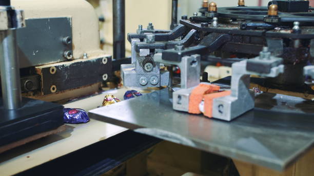 istock Industrial machine wrapping candies. Candy factory 1200280997
