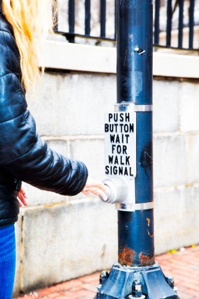 istock Blond woman pushing a crosswalk button 1200285684