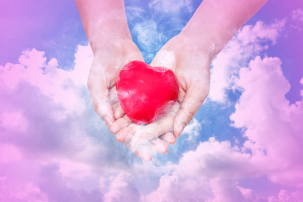 istock Red heart sign in hand with cloud nature background. 1200286139