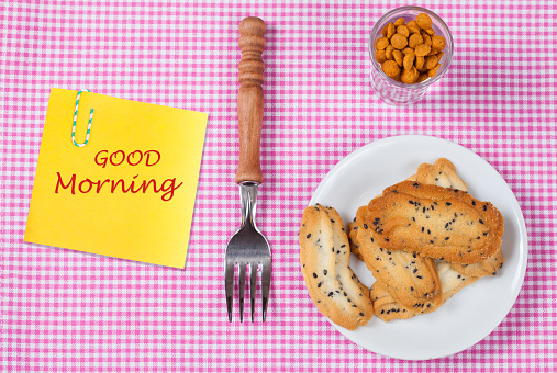 Good morning text on paper note with breakfast food on table.