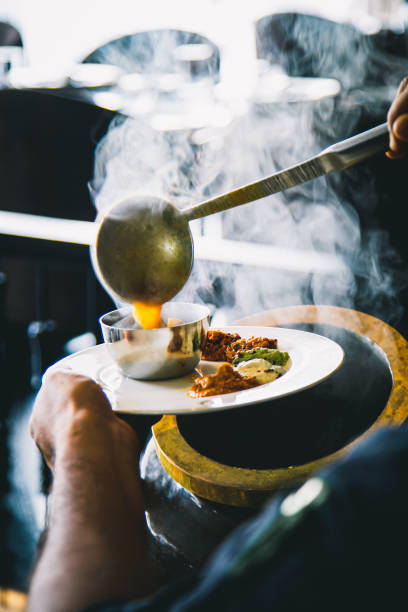 istock Indian employees scooping curry into a cup before serving, Indian Food 1200287574
