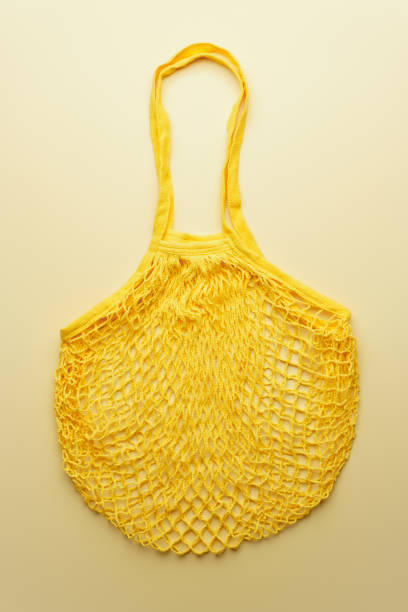 istock Reusable mesh product bag on yellow background. 1200290419