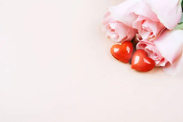 Photo of Beige banner with two glossy hearts and a bouquet of roses.