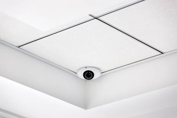 istock CCTV camera in the corner on a white suspended ceiling, security system close up. 1200291483