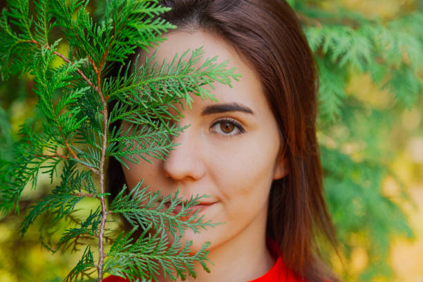 istock Beautiful woman in a green tree arborvitae 1200298156