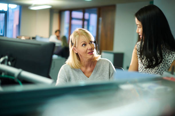 office colleagues a female call center worker listens to a colleague job retraining stock pictures, royalty-free photos & images