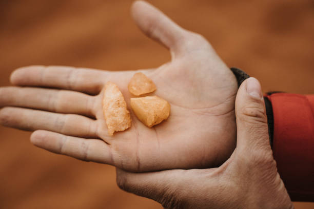 istock two hands holding and showing pieces of red quartz sandstone 1200301237