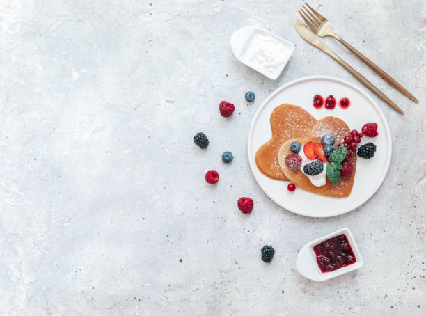 Flat Lay Romantic Breakfast in Bed, Heart shape Pancakes and Coffee stock photo