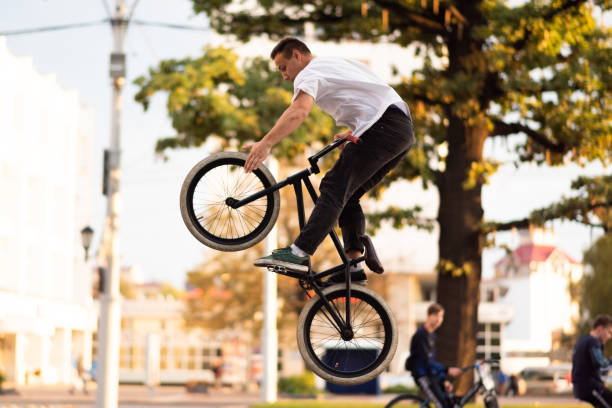 istock The guy performs a stunt on BMX, jumping high up, and touches the front wheel. 1200305726