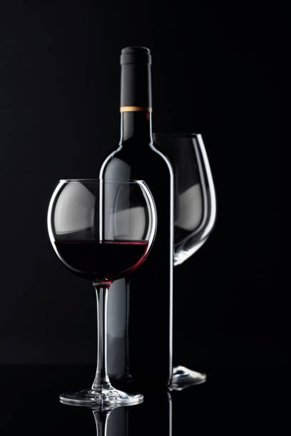istock Bottle and glasses of red wine on a black background. 1200306351