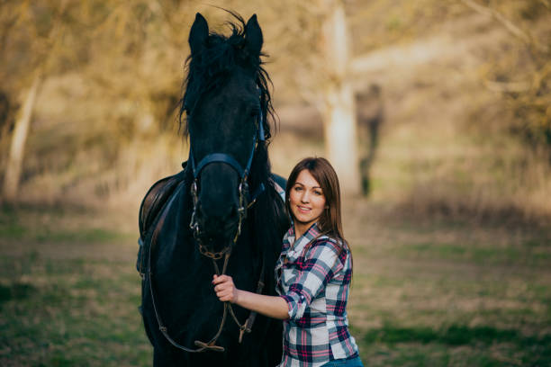 istock Young woman with horse in spring sun nature 1200306802