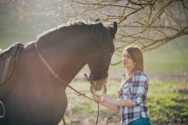 istock Young woman with horse in spring sun nature 1200306821