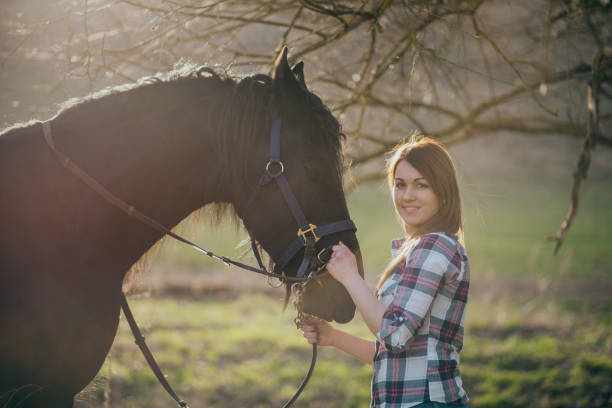 istock Young woman with horse in spring sun nature 1200306830