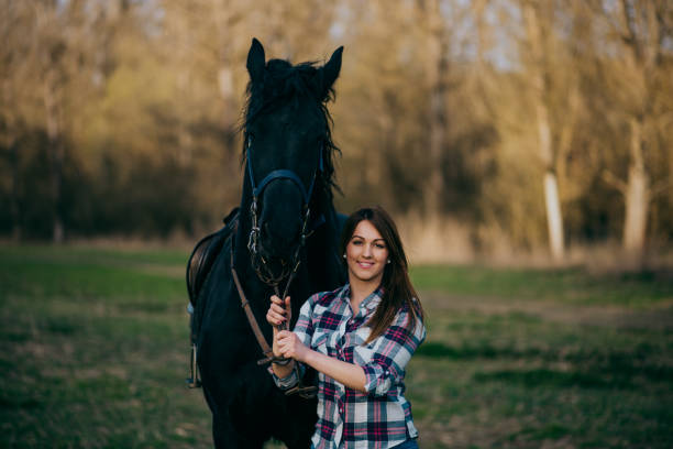 istock Young woman with horse in spring sun nature 1200307007
