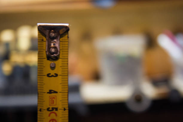 istock Yellow Measuring Tape on the black background. 1200308348