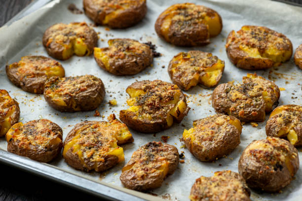 patatas crujientes asadas con ajo y parmesano. - smashed potatoes fotografías e imágenes de stock