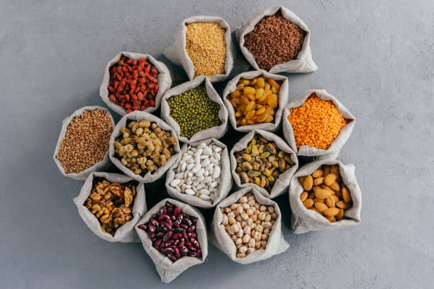 vista dall'alto di piccoli sacchetti con cereali: grano saraceno, lenticchie, haricot, ceci, goji, uvetta, pistacchio, pisello di chickasano, gelso, sicamina, mandorla. insieme di raccolte - legume bean chick pea sack foto e immagini stock