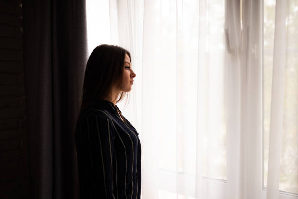 Brunette woman standing at window