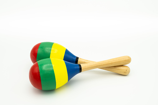 Closeup of a pair of colorful maracas lying on a white underground